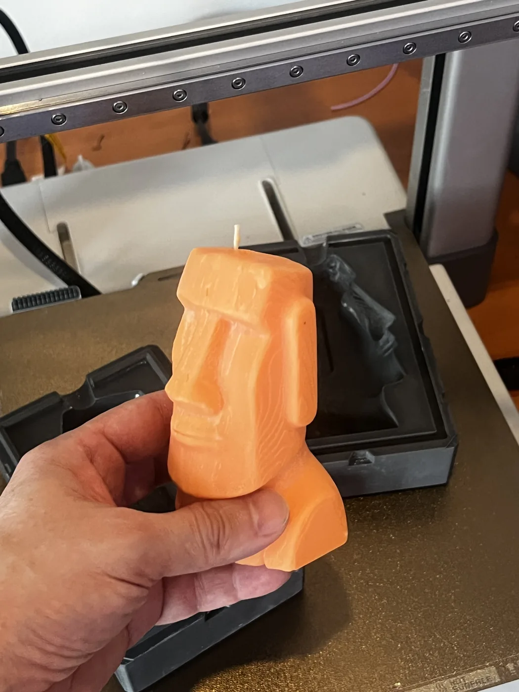 Moai candle cast in a 3DGEN silicone mold, held in hand