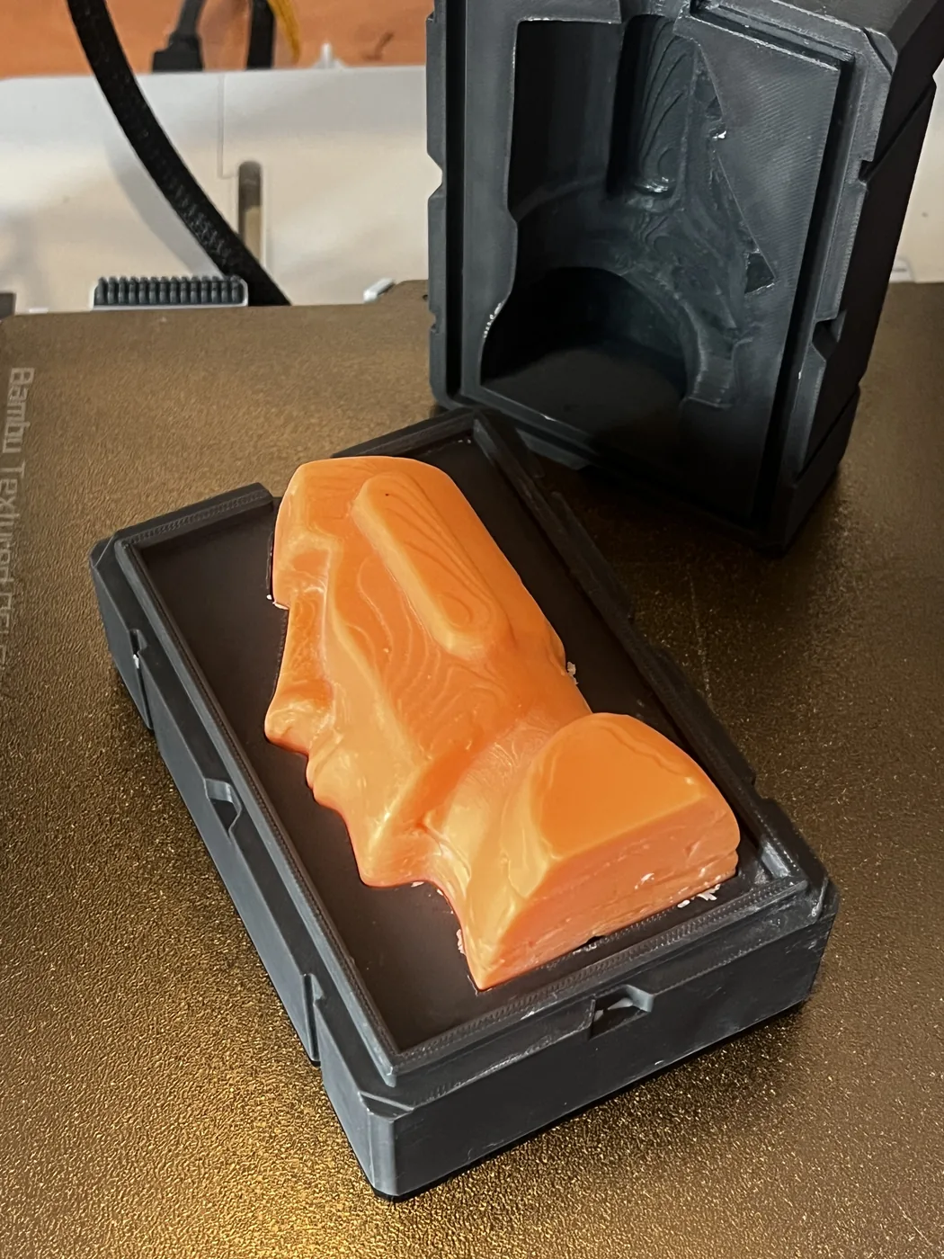 Freshly cast Moai candle sitting in its mold tray